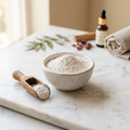 Pure white Multani Mitti Fuller's Earth powder in ceramic bowl with wooden scoop on marble surface